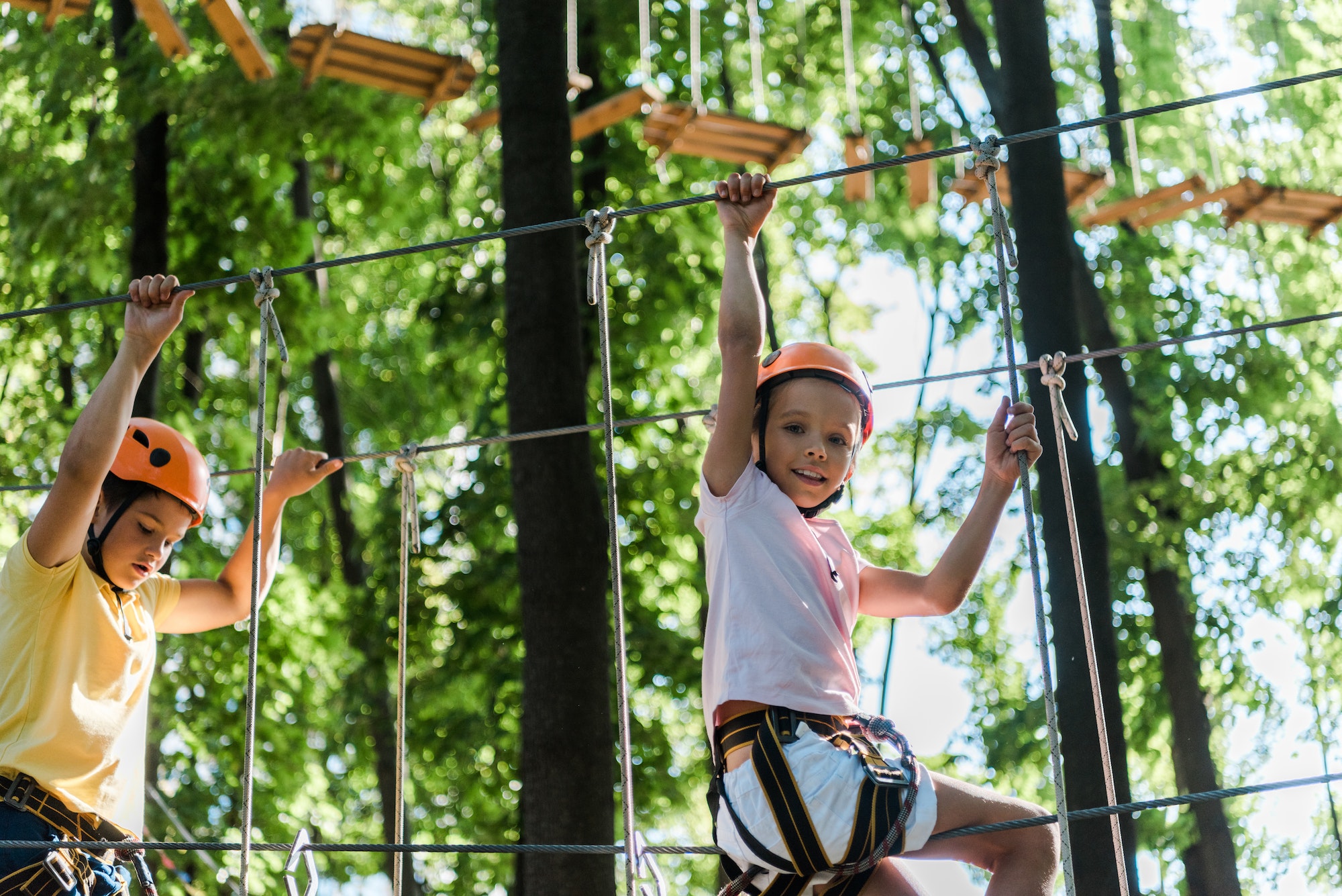 kids in helmets with height equipment in adventure park